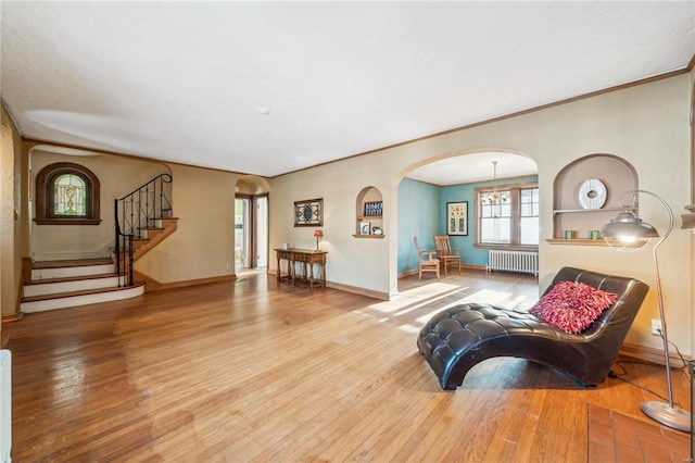 living room with ornamental molding, hardwood / wood-style floors, and radiator heating unit