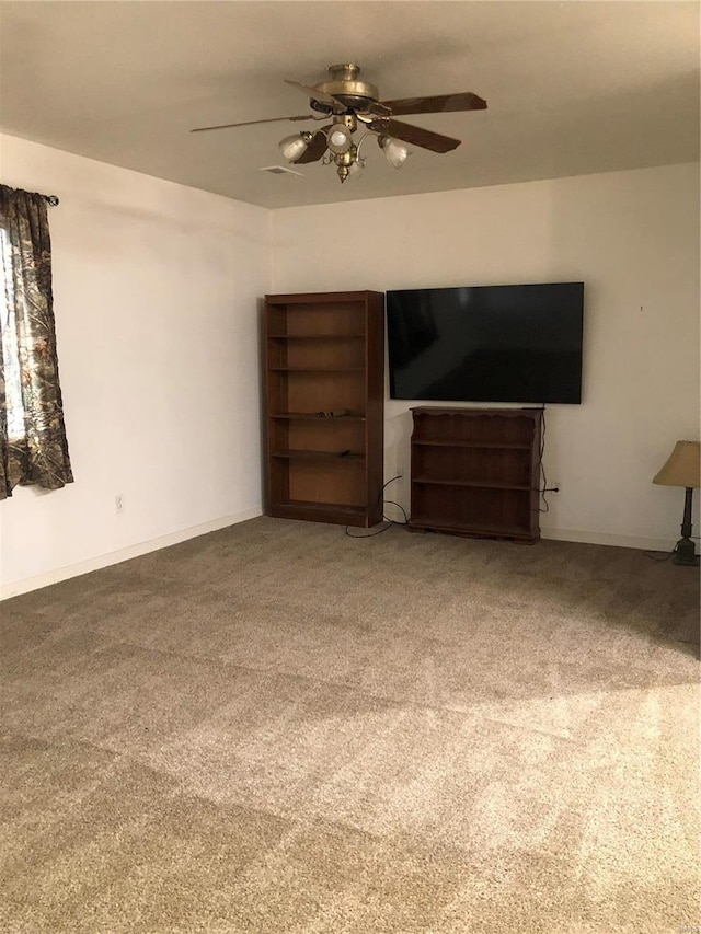 unfurnished living room with ceiling fan and carpet