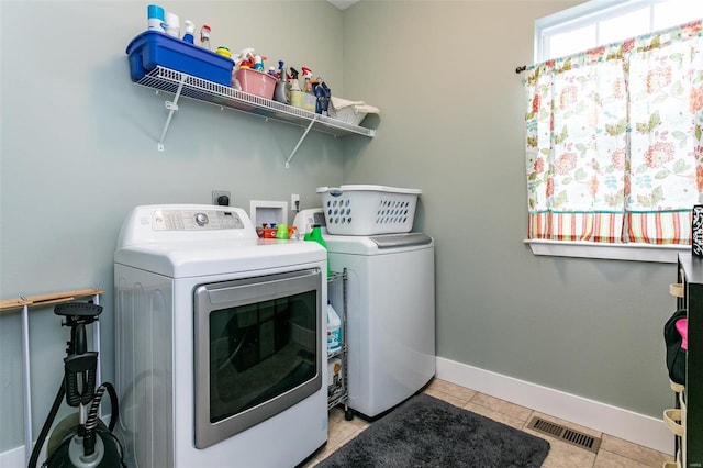 clothes washing area featuring light tile patterned flooring and independent washer and dryer