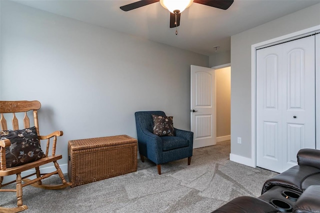 sitting room with ceiling fan and light colored carpet