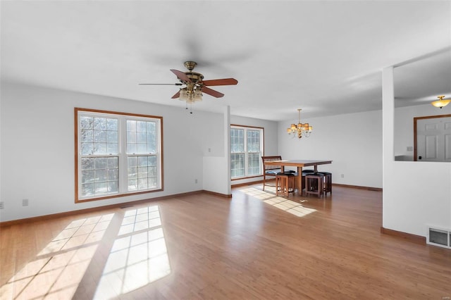 interior space featuring hardwood / wood-style floors and ceiling fan with notable chandelier