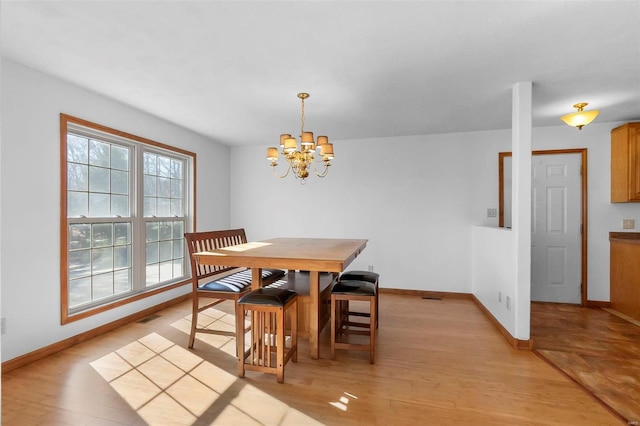 dining room featuring a notable chandelier and light hardwood / wood-style flooring