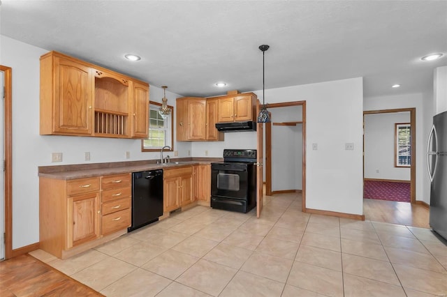 kitchen with pendant lighting, sink, light hardwood / wood-style floors, and black appliances