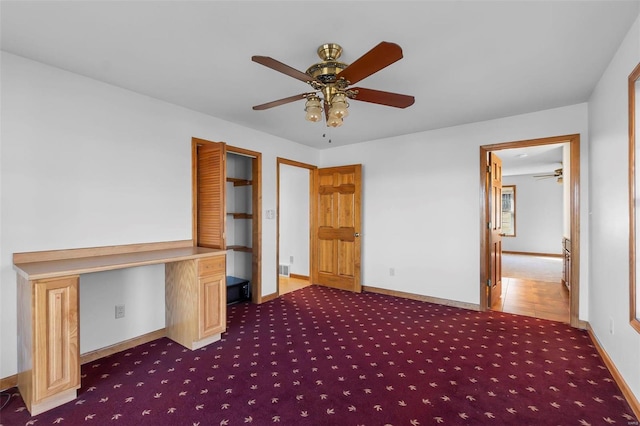 interior space featuring ceiling fan and built in desk