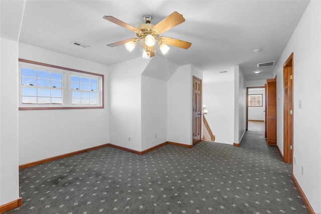 additional living space featuring dark colored carpet and ceiling fan