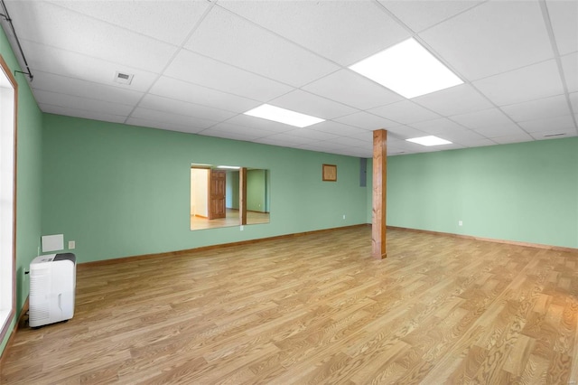 basement with a drop ceiling and light hardwood / wood-style floors