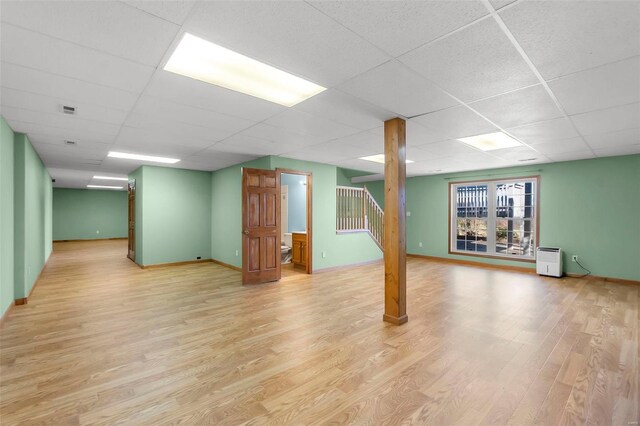 basement featuring light hardwood / wood-style flooring and a drop ceiling