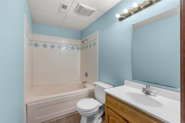 full bathroom with tile patterned flooring, vanity, tiled shower / bath combo, and toilet