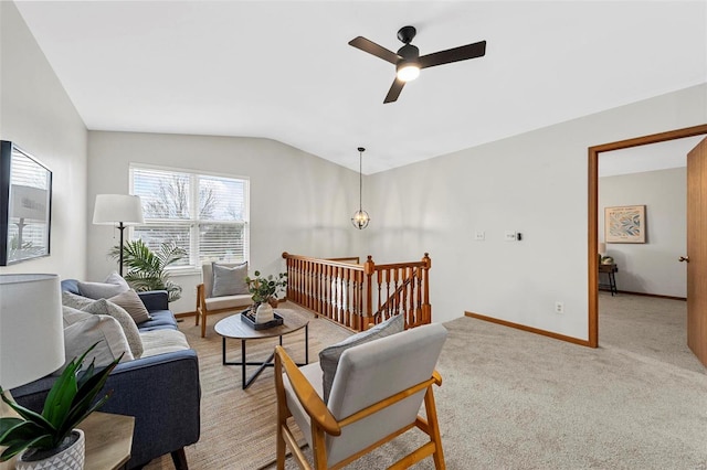 sitting room with ceiling fan, light colored carpet, an upstairs landing, baseboards, and vaulted ceiling