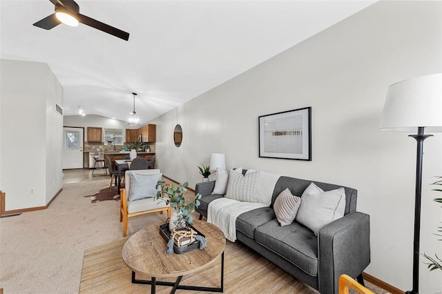 living area with lofted ceiling, baseboards, a ceiling fan, and light colored carpet