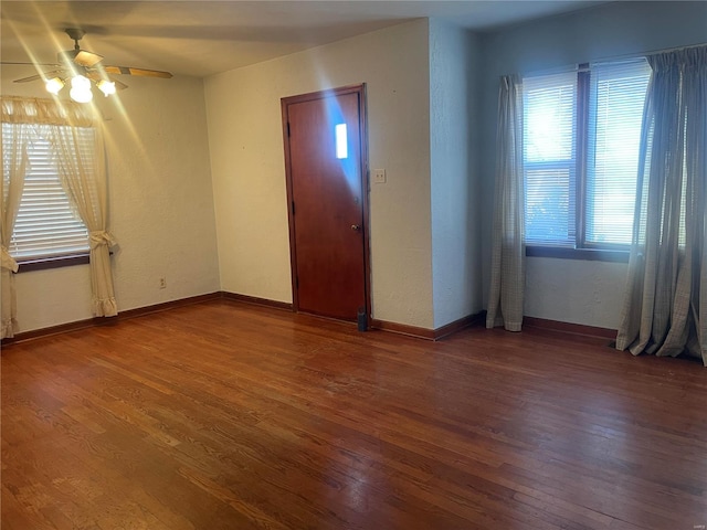 spare room featuring ceiling fan and dark wood-type flooring