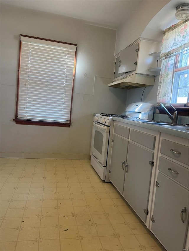 kitchen featuring white cabinetry, gas range gas stove, and extractor fan