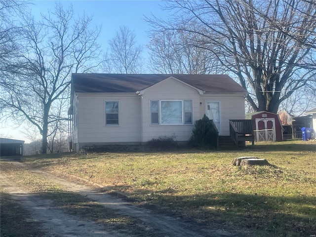 view of front of property featuring a storage unit and a front yard