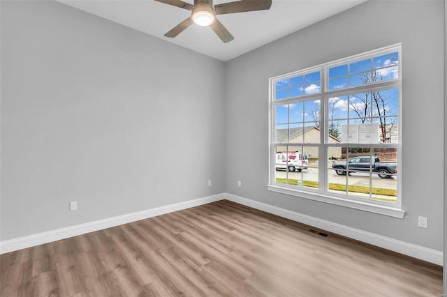 empty room with ceiling fan and light hardwood / wood-style floors