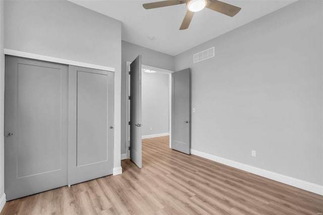 unfurnished bedroom with ceiling fan, light hardwood / wood-style floors, and a closet