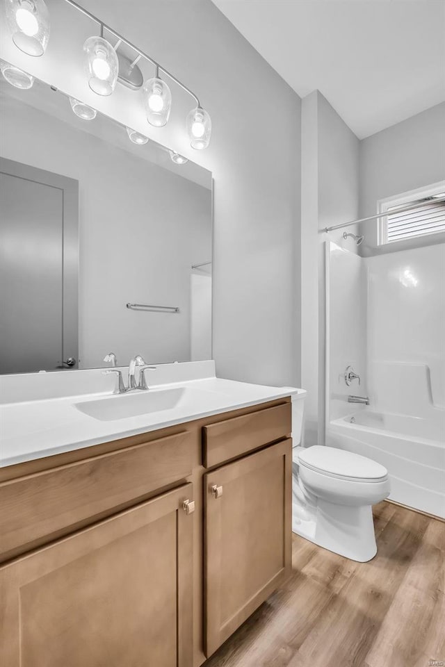 full bathroom featuring hardwood / wood-style flooring, vanity, toilet, and tub / shower combination