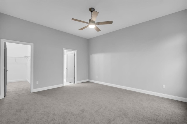 empty room featuring ceiling fan and light colored carpet