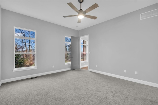 empty room featuring ceiling fan and carpet