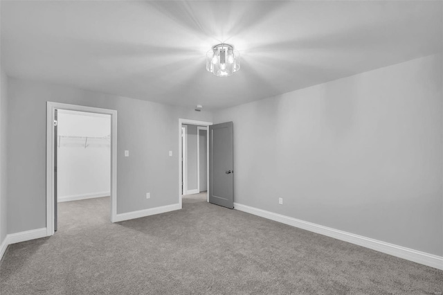 unfurnished bedroom with light colored carpet, a spacious closet, and a closet