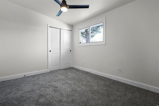 unfurnished bedroom featuring dark carpet, a closet, and ceiling fan