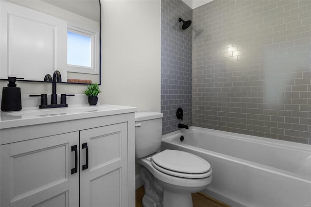 full bathroom featuring vanity, tiled shower / bath combo, and toilet