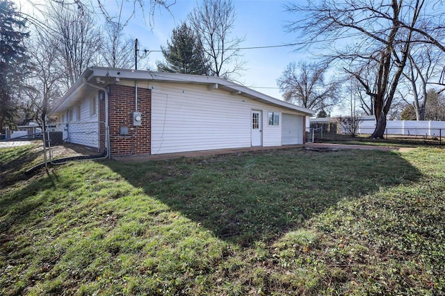 back of property featuring a garage and a yard