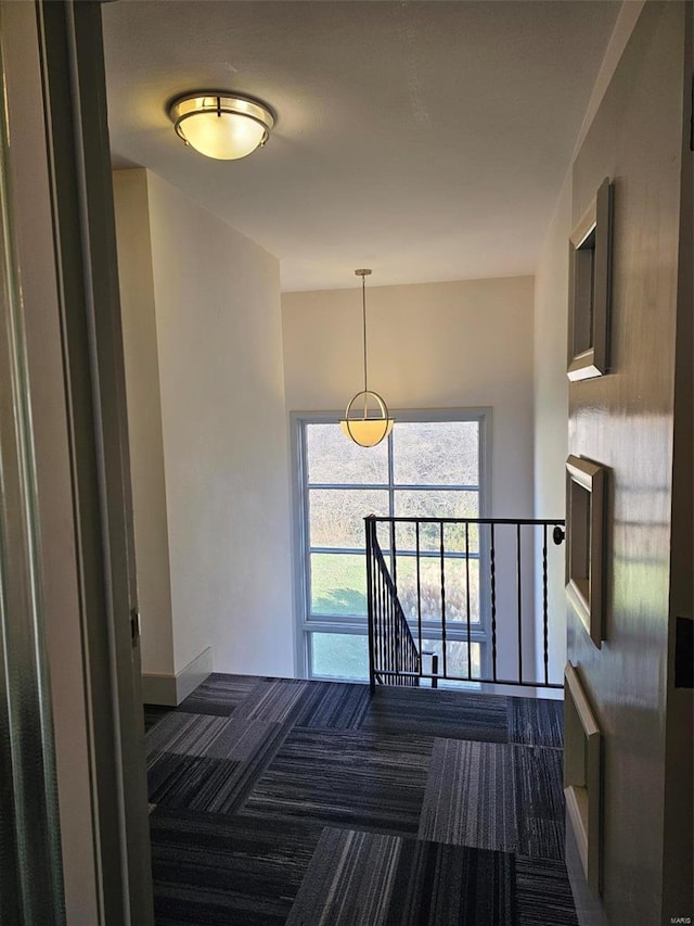 hall with dark colored carpet