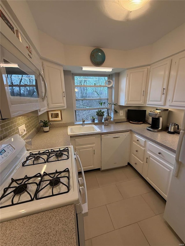 kitchen with sink, white cabinets, white appliances, and light tile patterned floors