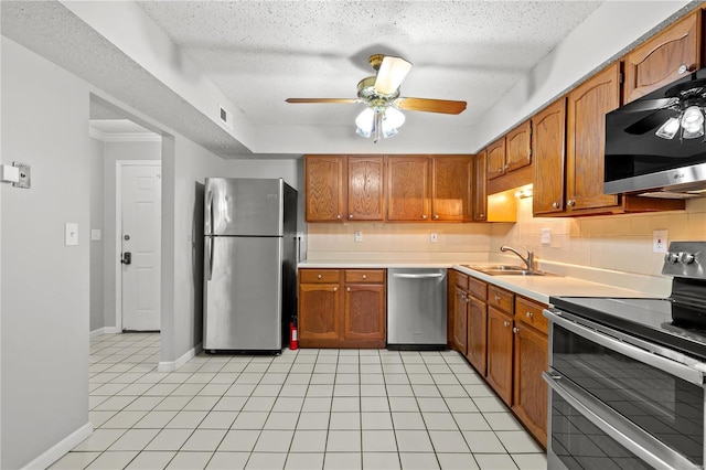 kitchen with backsplash, sink, light tile patterned floors, and stainless steel appliances