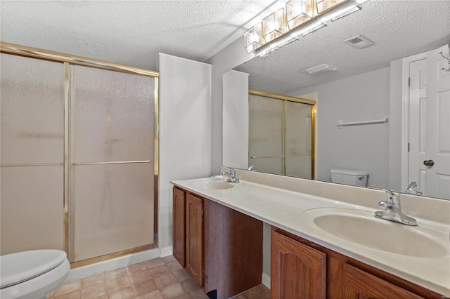 bathroom featuring a textured ceiling, vanity, toilet, and walk in shower