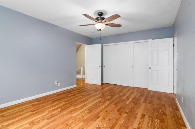 unfurnished bedroom featuring ceiling fan, light wood-type flooring, and a closet