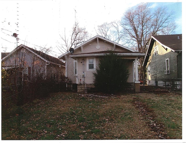 rear view of property with a lawn