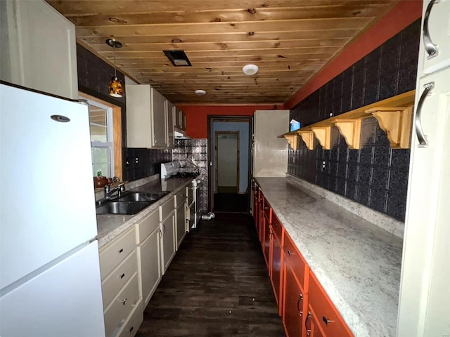 kitchen with sink, dark wood-type flooring, stainless steel range oven, white fridge, and white cabinets