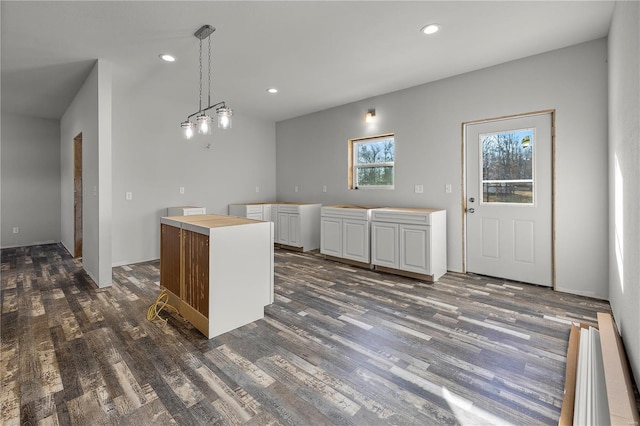 kitchen with a center island, decorative light fixtures, white cabinetry, and dark wood-type flooring