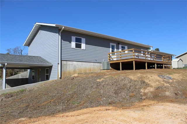 back of property featuring central AC unit and a deck
