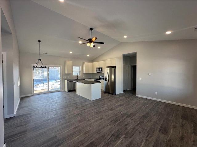 kitchen with dark wood-type flooring, white cabinetry, appliances with stainless steel finishes, a kitchen island, and pendant lighting