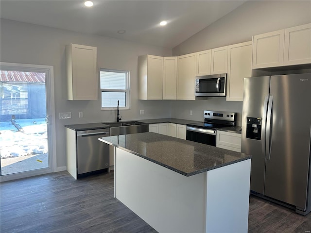 kitchen featuring white cabinetry, sink, dark stone countertops, a center island, and stainless steel appliances