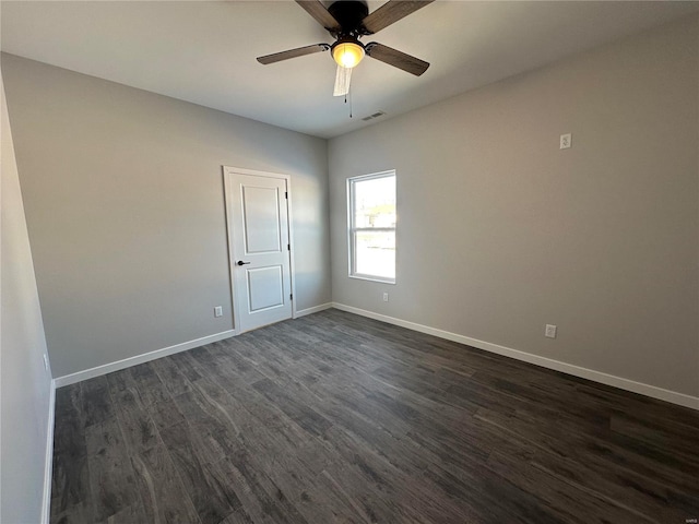 spare room featuring dark wood-type flooring and ceiling fan