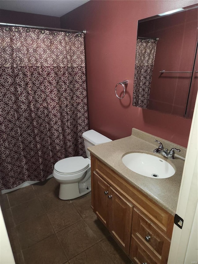 bathroom with tile patterned flooring, vanity, and toilet