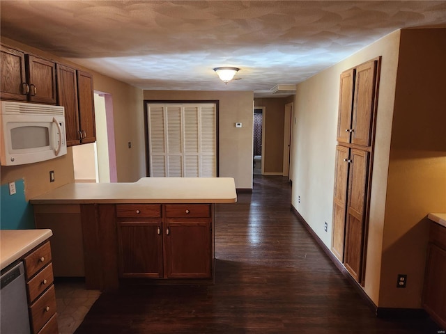 kitchen featuring kitchen peninsula, dark hardwood / wood-style floors, and dishwasher