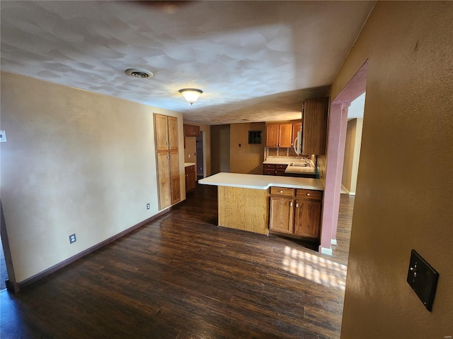 kitchen featuring dark hardwood / wood-style flooring and kitchen peninsula