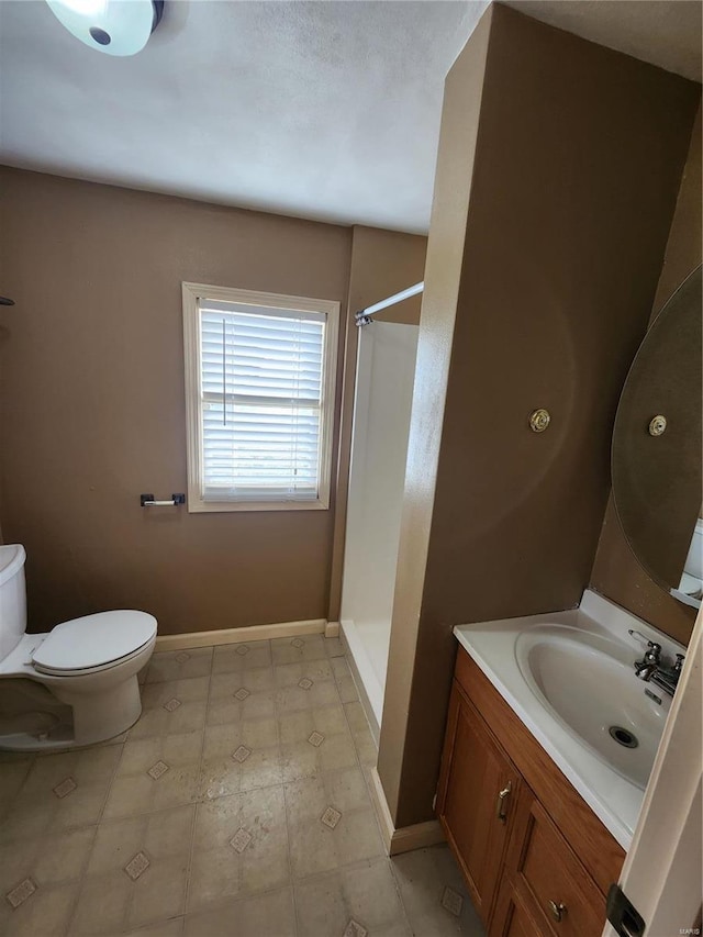 bathroom featuring a shower, vanity, and toilet