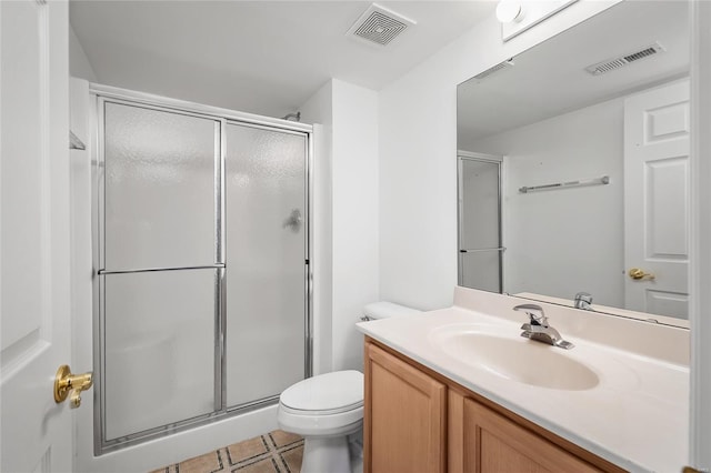 bathroom featuring vanity, toilet, and an enclosed shower