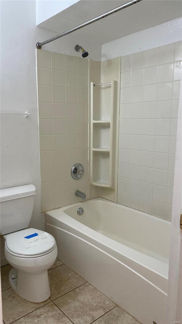 bathroom featuring tile patterned floors, tiled shower / bath combo, and toilet