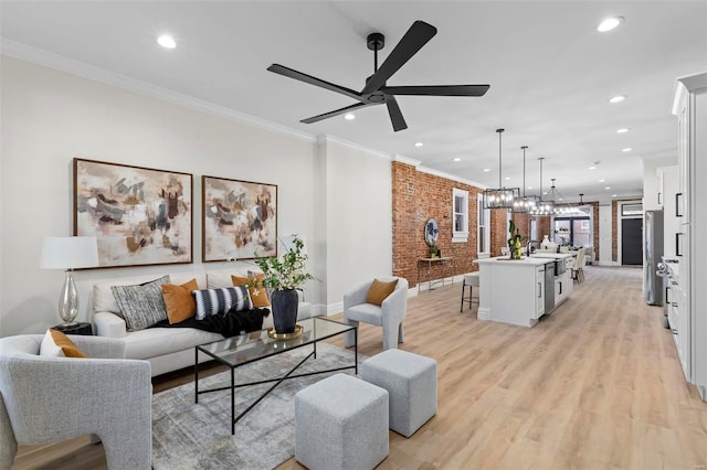 living room featuring light hardwood / wood-style flooring, ceiling fan, crown molding, and brick wall