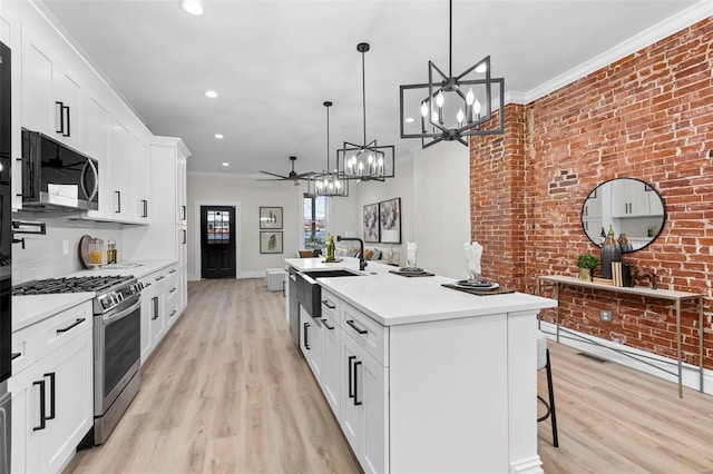 kitchen featuring white cabinetry, decorative light fixtures, ceiling fan with notable chandelier, and appliances with stainless steel finishes