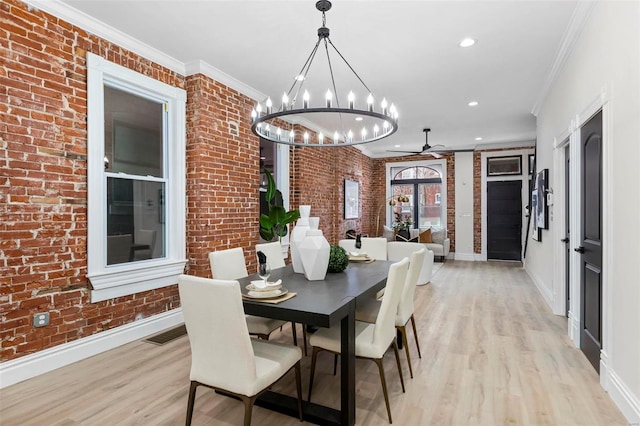 dining room with ornamental molding, brick wall, and light hardwood / wood-style floors