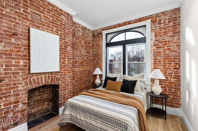 bedroom featuring hardwood / wood-style floors, brick wall, and ornamental molding