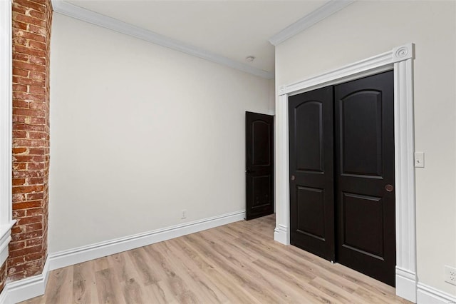 unfurnished bedroom featuring a closet, light hardwood / wood-style floors, and ornamental molding