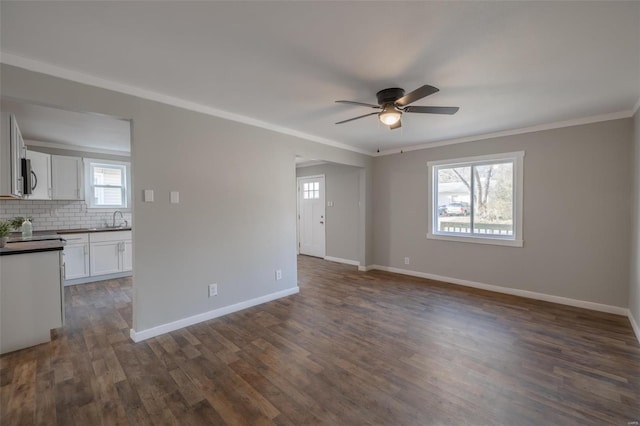 spare room featuring sink, ceiling fan, crown molding, and dark wood-type flooring